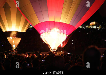 Heißluftballons in Bristol International Balloon Fiesta, bei Ashton Hof, Bristol, UK, 10. August 2017. Die Ballons steigen für eine Nacht Leuchten, eine Veranstaltung, die weniger Wetter abhängig zu sein, und in dem die Ballons auf dem Boden bleiben in der Gruppe und mit ihren Gasfackeln in der Zeit zu Musik Licht. Stockfoto