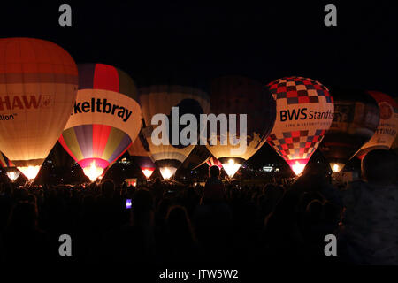 Heißluftballons in Bristol International Balloon Fiesta, bei Ashton Hof, Bristol, UK, 10. August 2017. Die Ballons steigen für eine Nacht Leuchten, eine Veranstaltung, die weniger Wetter abhängig zu sein, und in dem die Ballons auf dem Boden bleiben in der Gruppe und mit ihren Gasfackeln in der Zeit zu Musik Licht. Stockfoto