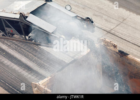 Straßenarbeiten. Asphalt entfernen Maschine laden in Pulverform Asphalt auf dem LKW Stockfoto