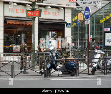 Bewaffnete Soldaten patrouillieren die Gegend um Gare do Nord Bahnhof in Paris Stockfoto