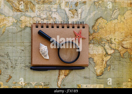 Reisen flach mit notepad Lupe und Muscheln seastar und schwarzen Stift auf der Karte platziert Stockfoto
