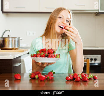 Langhaarige Frau Erdbeere im Hause essen Stockfoto