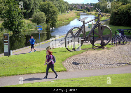 Einheimische wandern NCN 7 Pass die Bankies bike Skulptur an der Clydebank Sommerwetter und Einheimische genießen Sie den Sommer auf der Forth-and-Clyde-Kanal Leinpfad Stockfoto