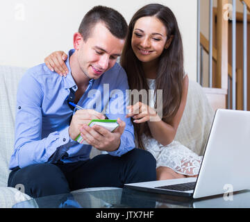 Junge europäische Familie Planung Käufe und Preise online prüfen Stockfoto