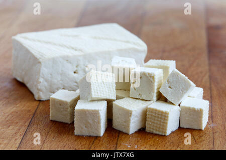 Einzelnen Block von weißen Tofu mit geschnittenen Tofu würfeln auf Holz Schneidebrett. Stockfoto
