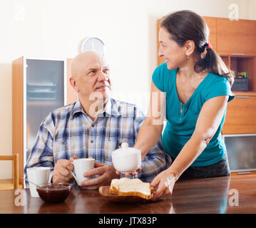 Glückliches junges Paar mit Frühstück am Morgen zu Hause Innenraum Stockfoto