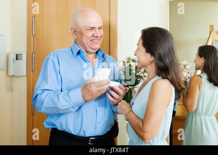 Gruß der liebevollen Reifes Paar mit Geschenken zu Hause Tür Stockfoto