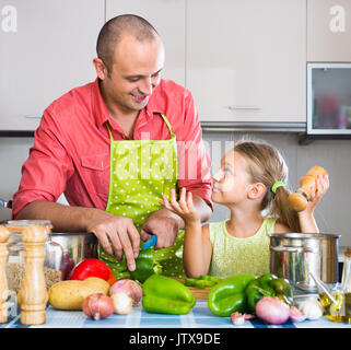 Kleines Mädchen helfen Vater Abendessen in der Küche vorbereiten Stockfoto