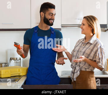 Spezialist für einheitliche Festsetzung tropfenden Wasserhahn, gerne fröhliche Blonde Stockfoto