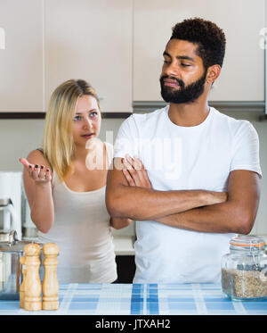 Junge unglücklich interracial Familie Paar mit ernsten Gesichtern in der Küche streiten. Im Mittelpunkt der Mensch Stockfoto