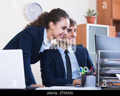 Lächelnd Top Manager Flirten mit Erwachsenen untergeordnete Offizielle am Arbeitsplatz Stockfoto