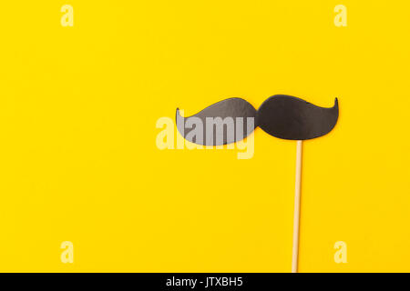 Schnurrbart auf einem Stock auf einem hellen gelben Hintergrund Stockfoto