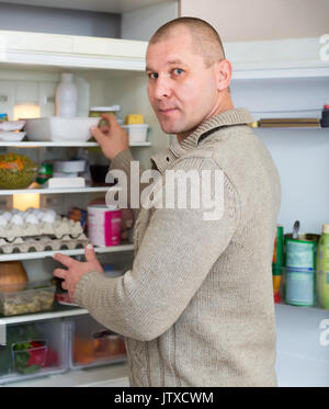 Hungrigen Mann in der Küche ist auf der Suche nach Essen im Kühlschrank Stockfoto