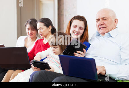 Glückliche Familie von drei Generationen mit einem Laptop auf dem Sofa zu Hause Stockfoto