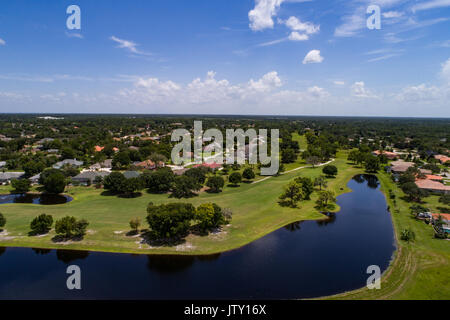 Luftaufnahme von einem Golfplatz in einer Wohnanlage. Bild zeigt Häuser, die Fairways und einen kleinen See oder Körper des Wassers. Stockfoto