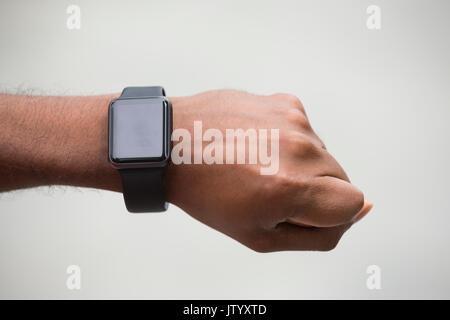 Nahaufnahme eines indischen Mann an seinem smartwatch Pulsmesser suchen. Asiatischer Mann mit einem smart Watch. Stockfoto