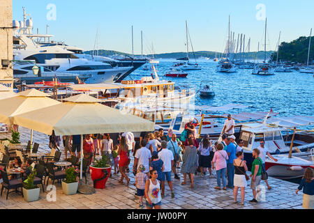 Touristen in Hvar Hafen bei Sonnenuntergang in der alten Stadt Hvar. Main Pjaca Platz vor der St.-Stephans-Kirche. Stockfoto