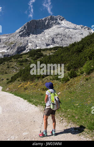 Weibliche Wanderer stoppen der Blick auf den Berg zwischen Kreuzeck und Alpspitz, Sommerzeit, Zugspitzland, Bayern, Deutschland zu bewundern. Stockfoto