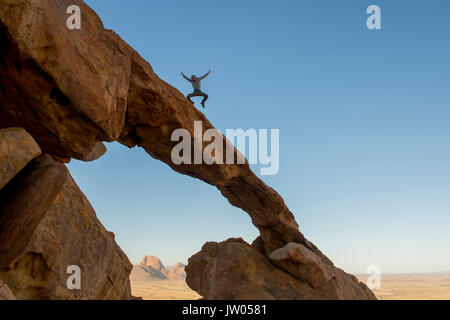 Foto von Mann springen auf Rock Arch, Spitzkoppe, Erongo Region, Namibia Stockfoto