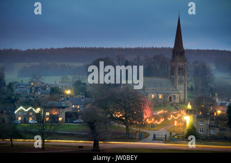 Weihnachtslichter leuchten Edensor Dorf auf dem Chatsworth Estate, Derbyshire im Dezember), Großbritannien Stockfoto