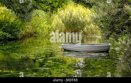 Impressionistische Szene am Beth Chatto Ggardens, Elmstead Market, Essex, England, UK: Stilleben mit Schiff in einen Teich. Stockfoto