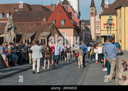 Ein beliebter Zeitvertreib in der deutschen Stadt Würzburg ist ein Treffen mit Freunden bei einem Glas (oder auch zwei) Der fränkischen Wein auf der alten Brücke. Stockfoto