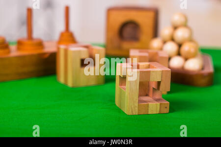 Holzblock Denksport puzzle am grünen Tisch in einer unscharfen Hintergrund Stockfoto