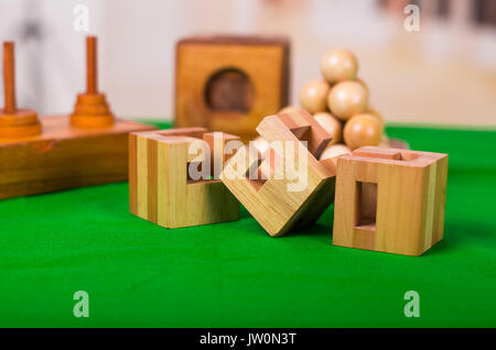 Holzblock Denksport puzzle am grünen Tisch in einer unscharfen Hintergrund Stockfoto