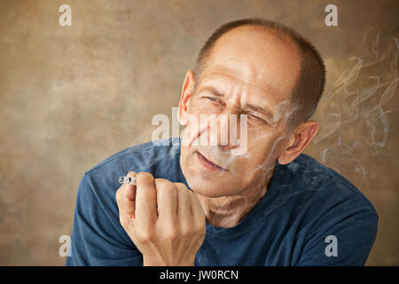 Besorgt reifer Mann im Studio sitzen Stockfoto