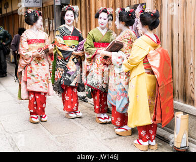 Fünf Geisha in atemberaubenden Kimonos, posieren für Fotos, in einem traditionellen Kyoto street in Japan Stockfoto