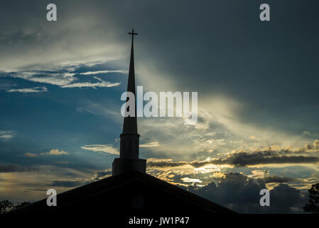 Sonnenuntergang hinter ein Kirchturm nach einem verregneten Nachmittag. Stockfoto