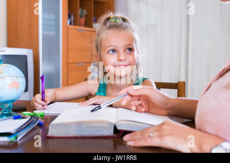 Spanische private Lehrer und kleine Mädchen studieren mit Notizen zu Hause Stockfoto