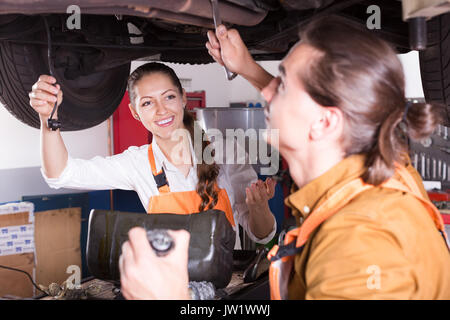 Stattliche Mechaniker und schönen weiblichen Assistenten arbeiten in Werkstatt Stockfoto