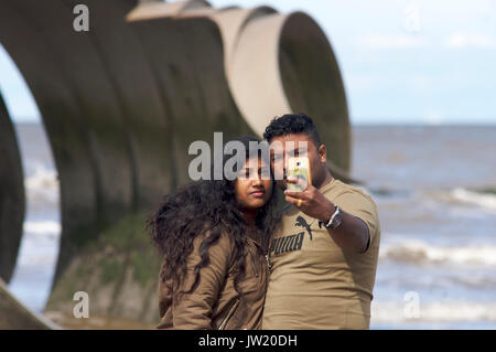 Asiatische Paar unter selfie vor Mary's Shell Skulptur am Strand von Cleveleys, Lancashire, Großbritannien Stockfoto