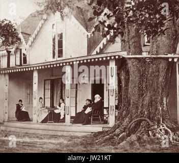 Harriet Beecher Stowe (1811–1896) und ihr Ehemann Calvin Ellis Stowe, zusammen mit ihren Töchtern, auf der Veranda ihres Winterhauses nach dem Bürgerkrieg in Mandarin, Florida, mit Blick auf den St. Johns River. Die Stowes waren Abolitionisten und Mrs. Stowe war eine Autorin, die vor allem für ihren Roman Onkel Toms Hütte bekannt war. Die Stowes überwinterten zwischen 1867 und 1884 in Mandarin (heute ein Viertel von Jacksonville). Geschichten über Mandarin werden in dem Buch Palmetto Leaves von Harriet zusammengestellt. Die Stowes veranstalteten Bibelstudien in ihrem Haus, wo Calvin lehrte, oft auf der hier abgebildeten Veranda. Stockfoto