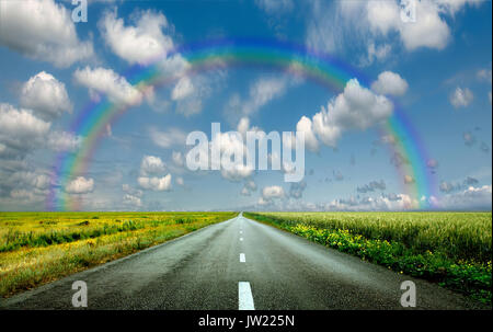 Bild der weiten Prärie mit eine asphaltierte Straße erstreckt, so weit das Auge sehen kann mit schönen kleinen grünen Hügeln unter strahlend blauem Himmel in t Stockfoto