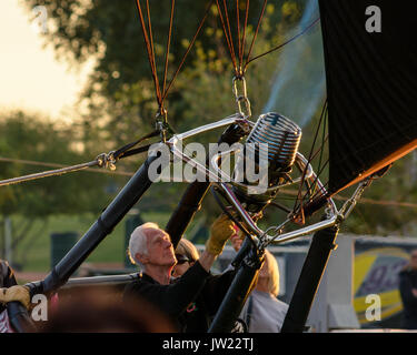 Ältere Mann bläst warme Luft in den Ballon in der Vorbereitung für den Start an der Colorado River Crossing Balloon Festival in Yuma, AZ November 2016 Stockfoto