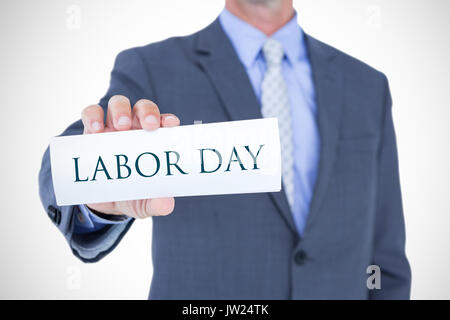 Mittelteil der Geschäftsmann Holding eine leere Karte gegen Labour day text Stockfoto