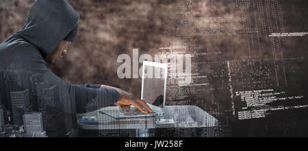 Männliche Hacker mit Laptop auf dem Tisch gegen Braun strukturierten Hintergrund Stockfoto