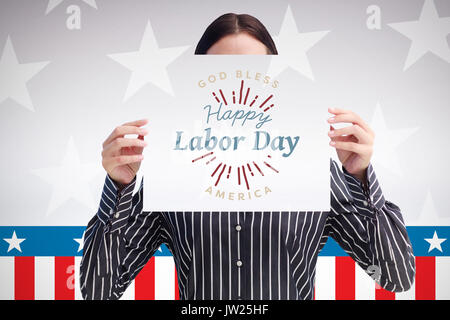 Lächelnde Frau mit einem großen Geschäft Karte vor ihrem Gesicht gegen digital erzeugten Bild der Bühne Stockfoto