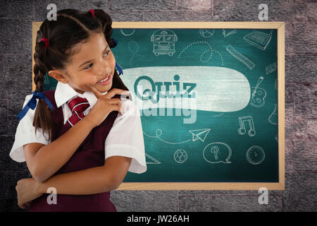 Nachdenklich Schulmädchen auf weißem Hintergrund gegen Quiz gegen grüne Tafel Stockfoto