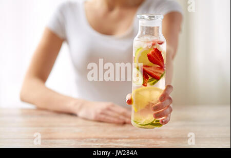 Nahaufnahme von Frau mit Fruchtwasser in Glasflasche Stockfoto