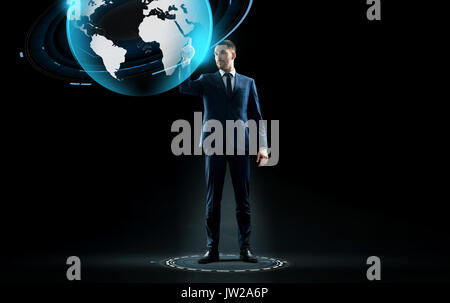 Geschäftsmann im Anzug berühren Erde Globus Hologramm Stockfoto