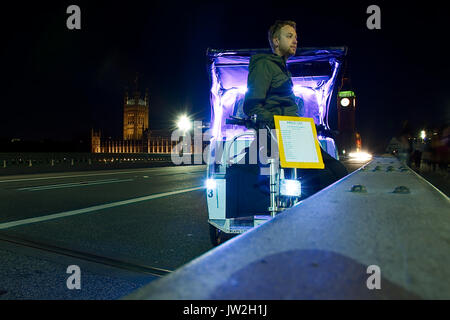 Rikscha Fahrer für Kunden auf die Westminster Bridge, London in der Nacht warten, Sommer 2017. Big Ben und die Houses of Parliament in Hintergrund, violett-LED leuchtet. Stockfoto