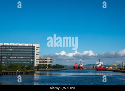 Albert Dock Bassin, Leith, Edinburgh mit Offshore Supply Schiffe gegen den blauen Himmel und das Bürogebäude mit großen Banner Büro zu lassen, Schottland Stockfoto