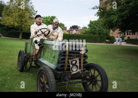 Rennwagen Paris nach Wien Fahrer Fahrernummer Lenkradhelm Helme Gras schnell langsame Räder Soft Top Fahrzeug grün lackierte Farbe Mann Stockfoto