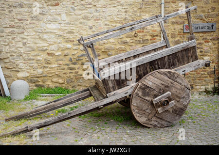 Alten hölzernen Wagen mit einem Stein gemauerte Wand im Hintergrund mit einem 'Cartiera' Zeichen (Papierfabrik in italienischer Sprache). Stockfoto