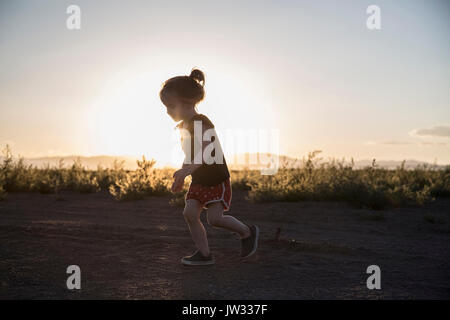 USA, Colorado, kleines Mädchen (4-5), die auf Schmutz der Straße bei Sonnenuntergang Stockfoto