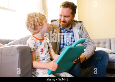 Vater und Sohn (4-5) das Spiel mit dem elektronischen Spielzeug Stockfoto