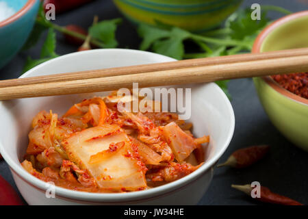 Kimchi - Koreanische superfood. Eingelegte Chinakohl in Schüssel auf schiefer Platte Stockfoto